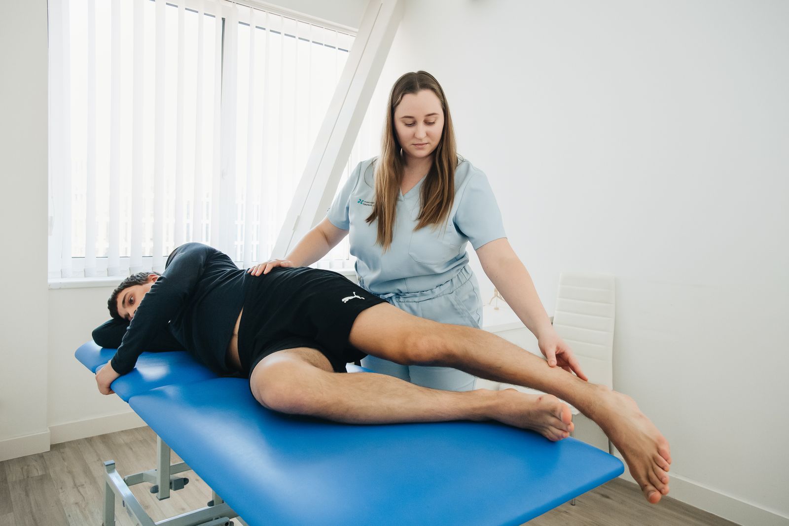A physiotherapist working with a client on a treatment table